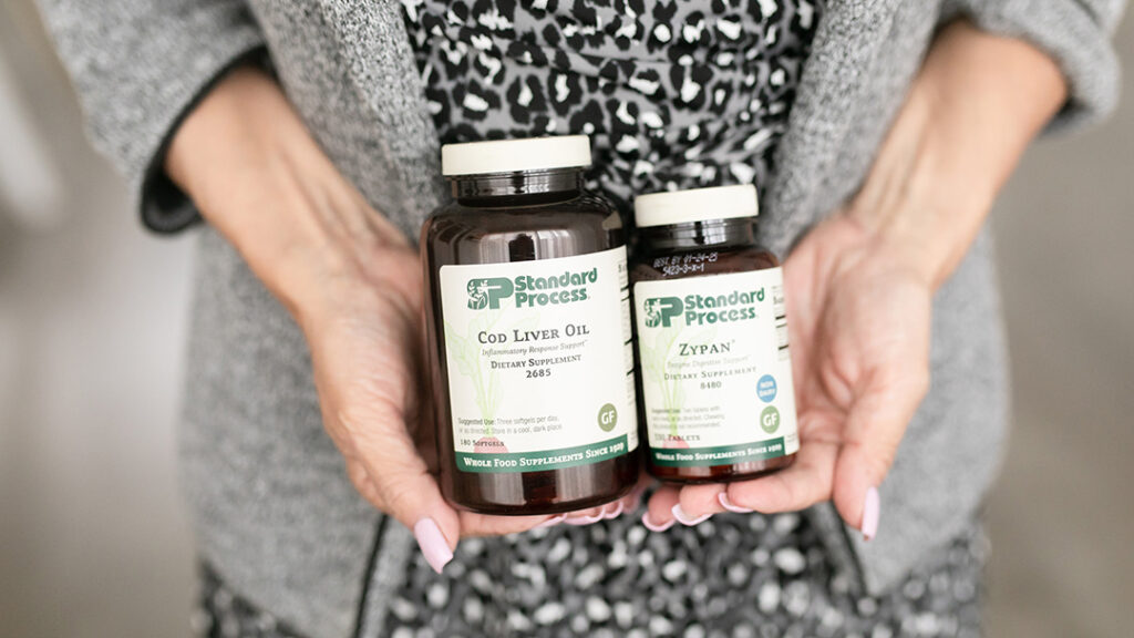 a person holding two bottles of vitamins for gut health