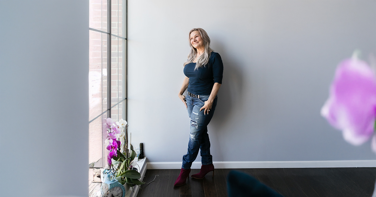 Dawna leaning against the wall looking out a window - perimenopause and menopause nutrition